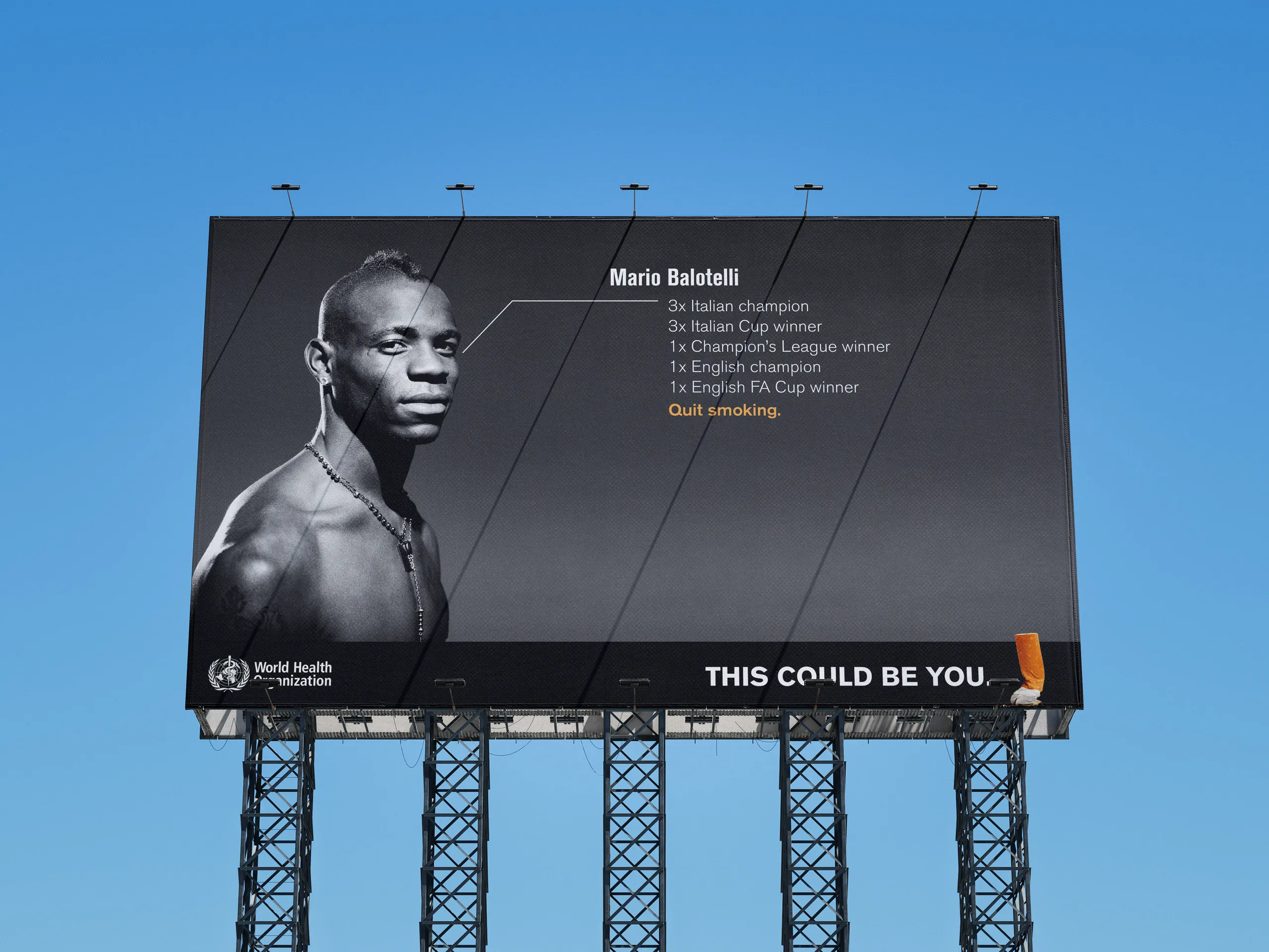 Black and white billboard of a shirtless footballer, his list of titles ending in “Quit smoking,” and the line “This could be you.”