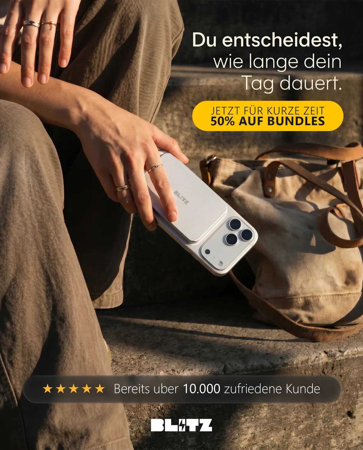 German-language Meta ad: a hand holding a phone with the silver power bank by a canvas bag, 50% off bundles