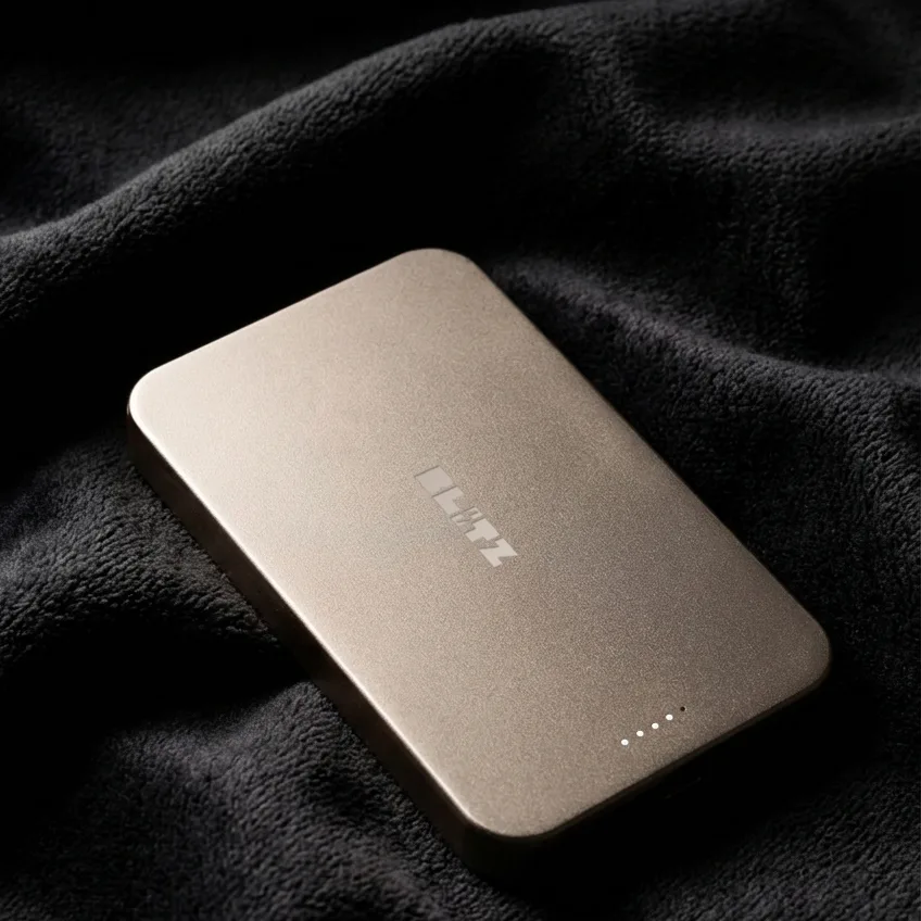 Close-up of the rose gold Blitz Charge power bank on dark wool fabric